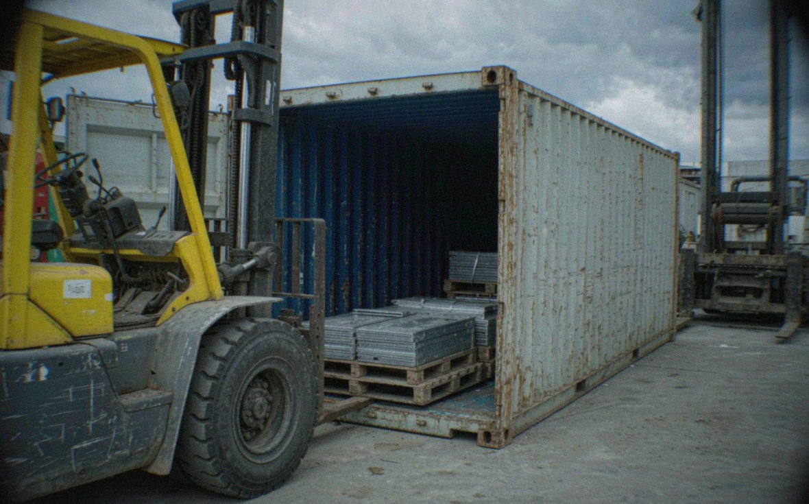 Fumigated wooden pallets of aluminium plate strapped and loaded into a container
